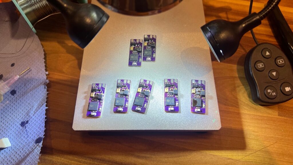 Seven assembled purple Micro WLED controller boards on a work surface